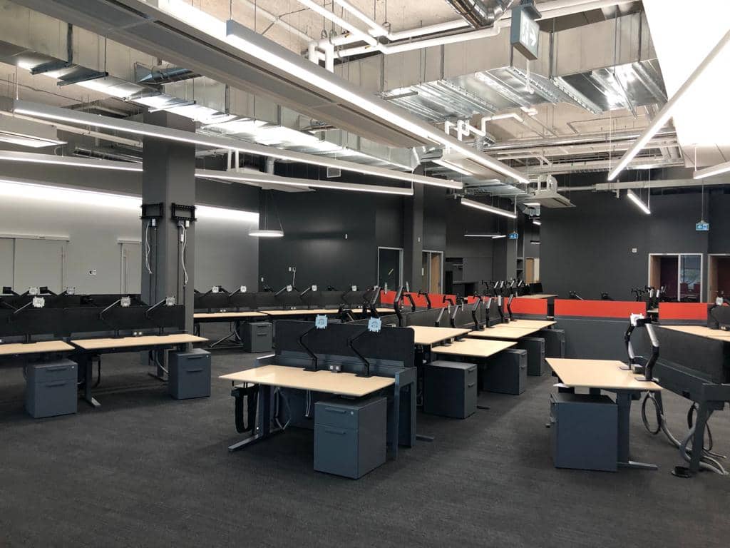 Open-plan corporate workspace installed by Noova Express, with height-adjustable desks and privacy screens